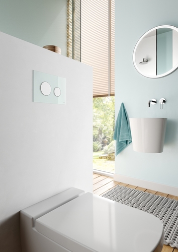 Aranżacja łazienki w pastelowym odcieniu mięty - miętowe przyciski spłukujące do WC